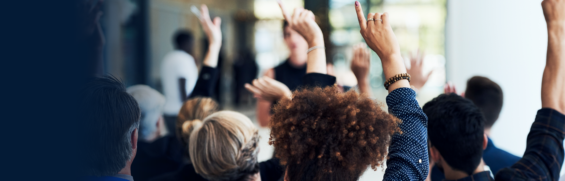 People raising their hand in a class desktop