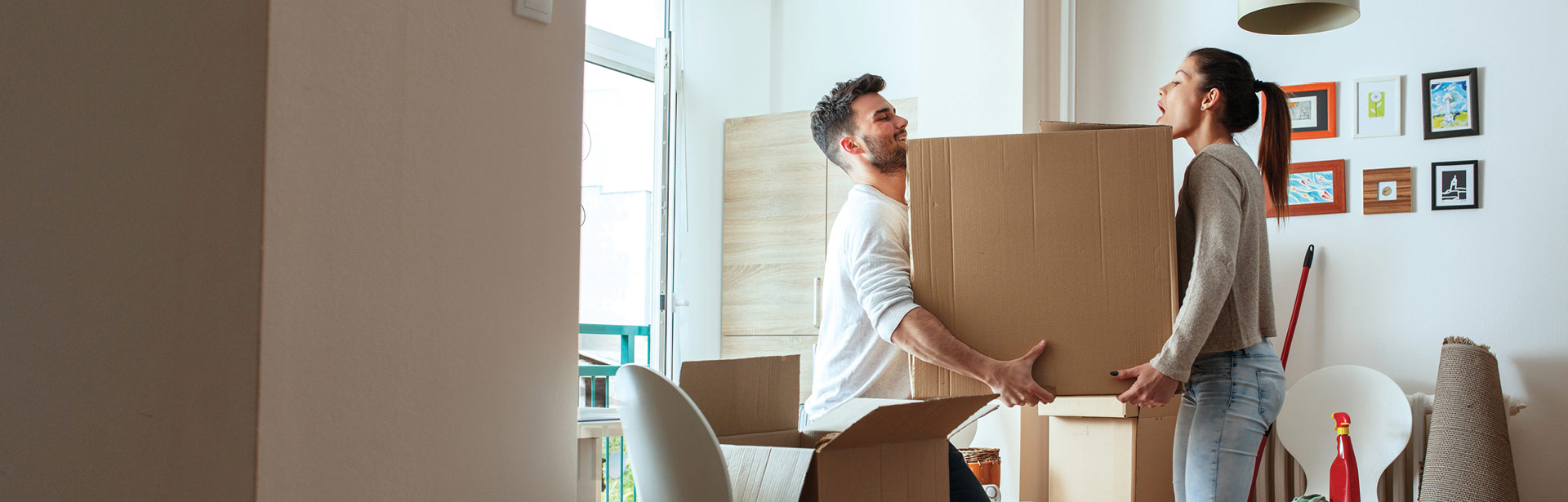 A couple moving boxes in their new home